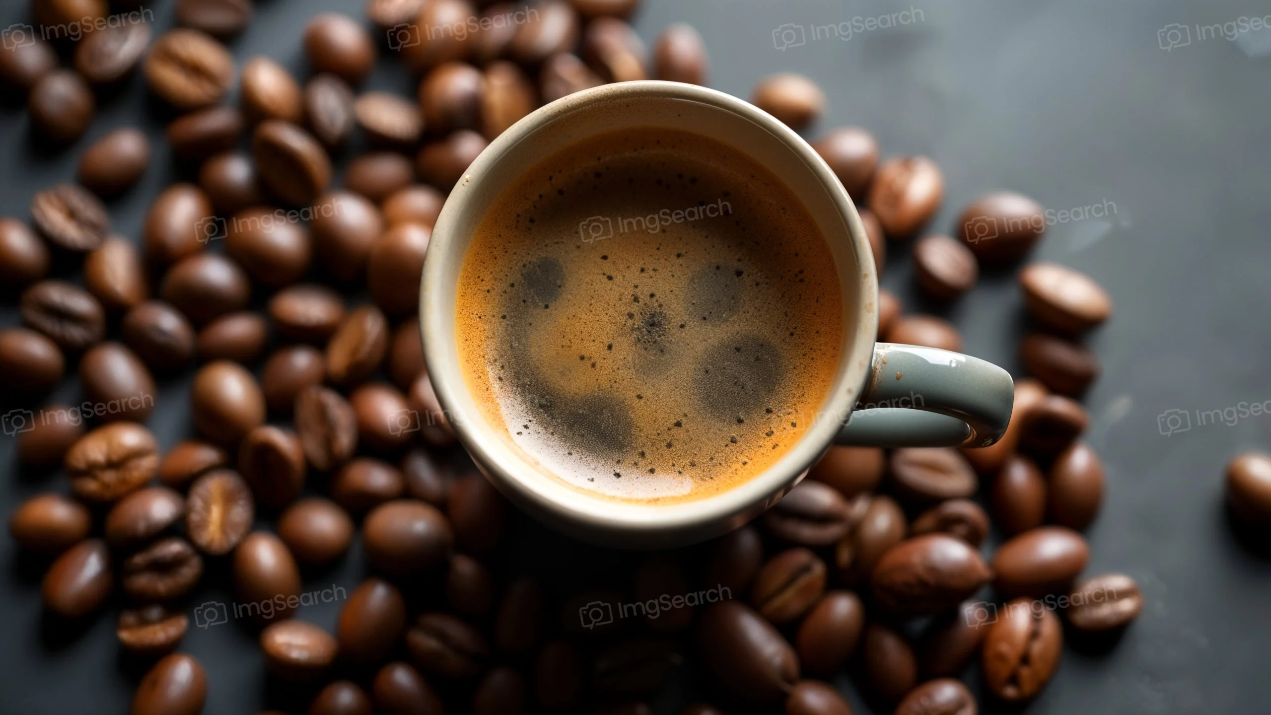 A cup of coffee filled with aromatic brew, surrounded by coffee beans