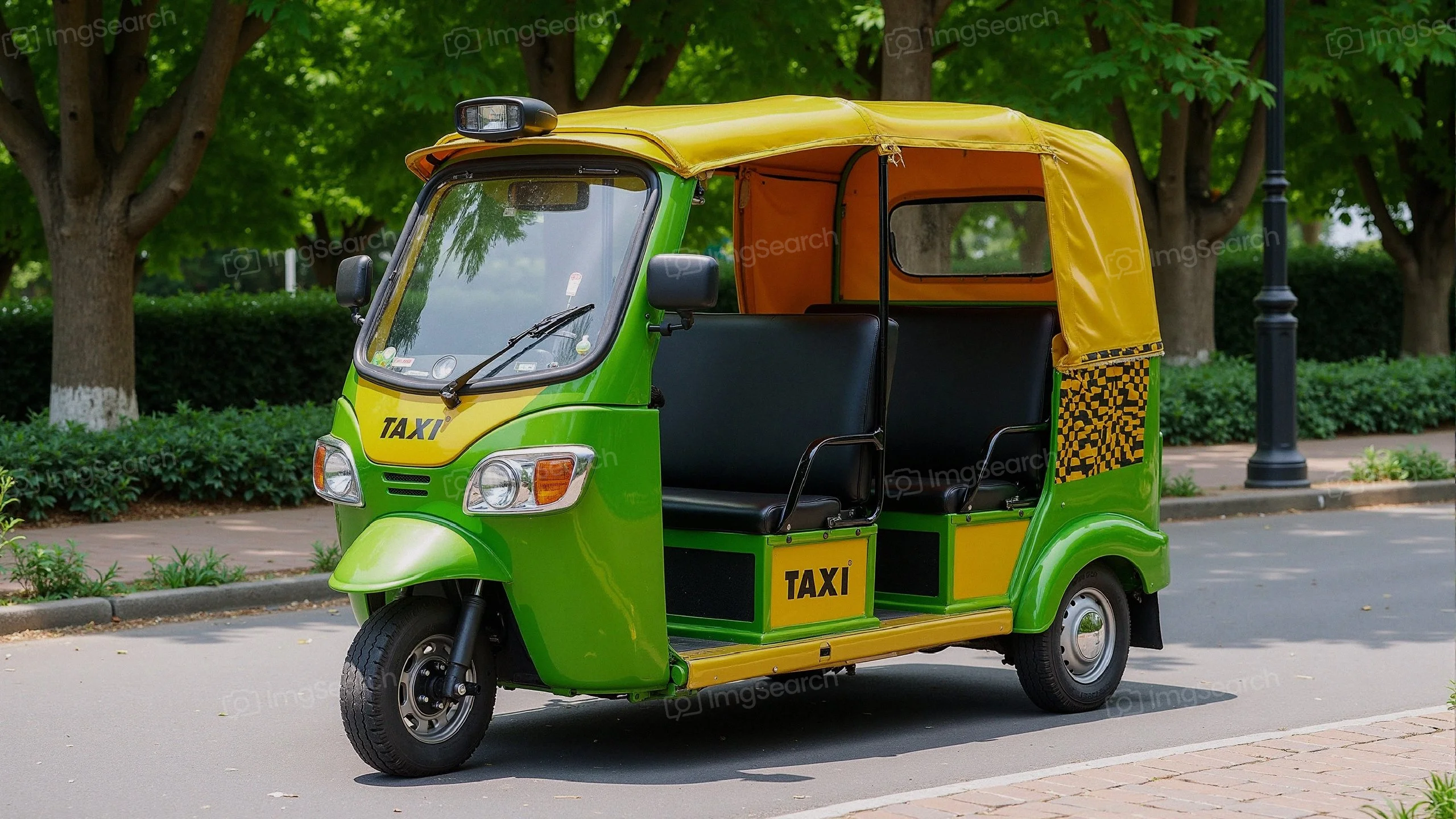 A green yellow auto rickshaw parked on a tree-lined street, with a taxi sign visible.