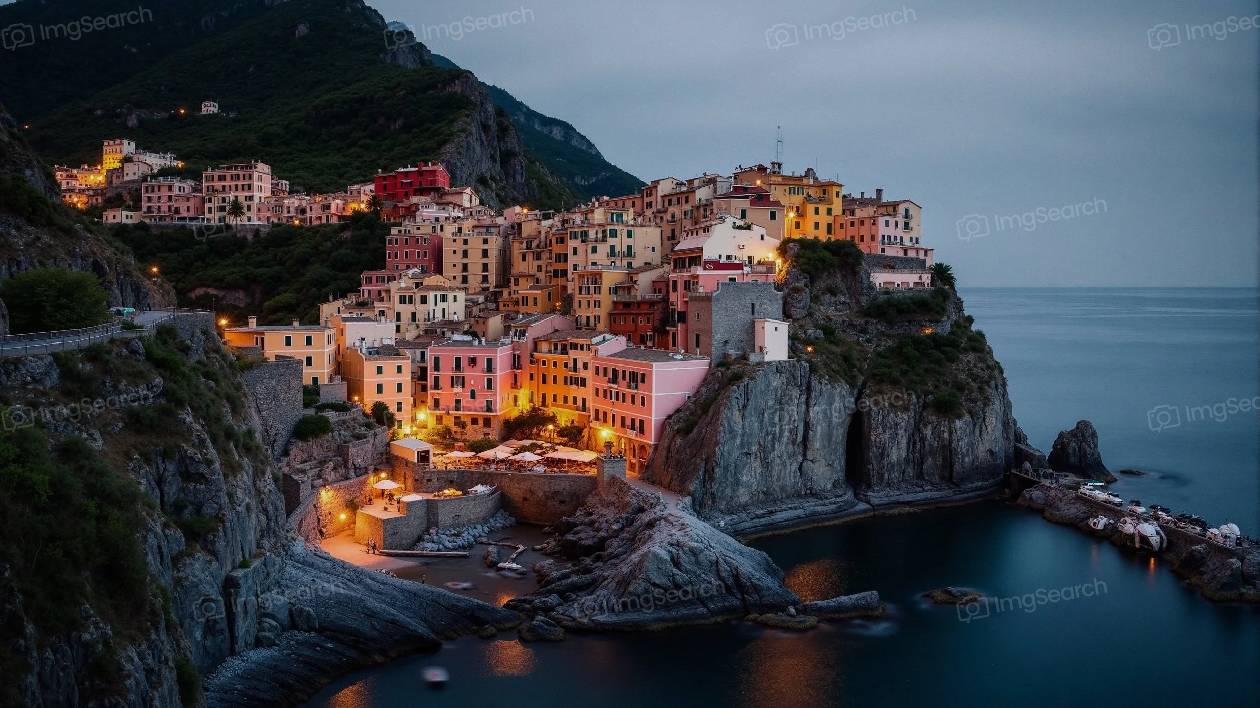 A picturesque coastal village illuminated at dusk, reflecting colorful buildings on the water.