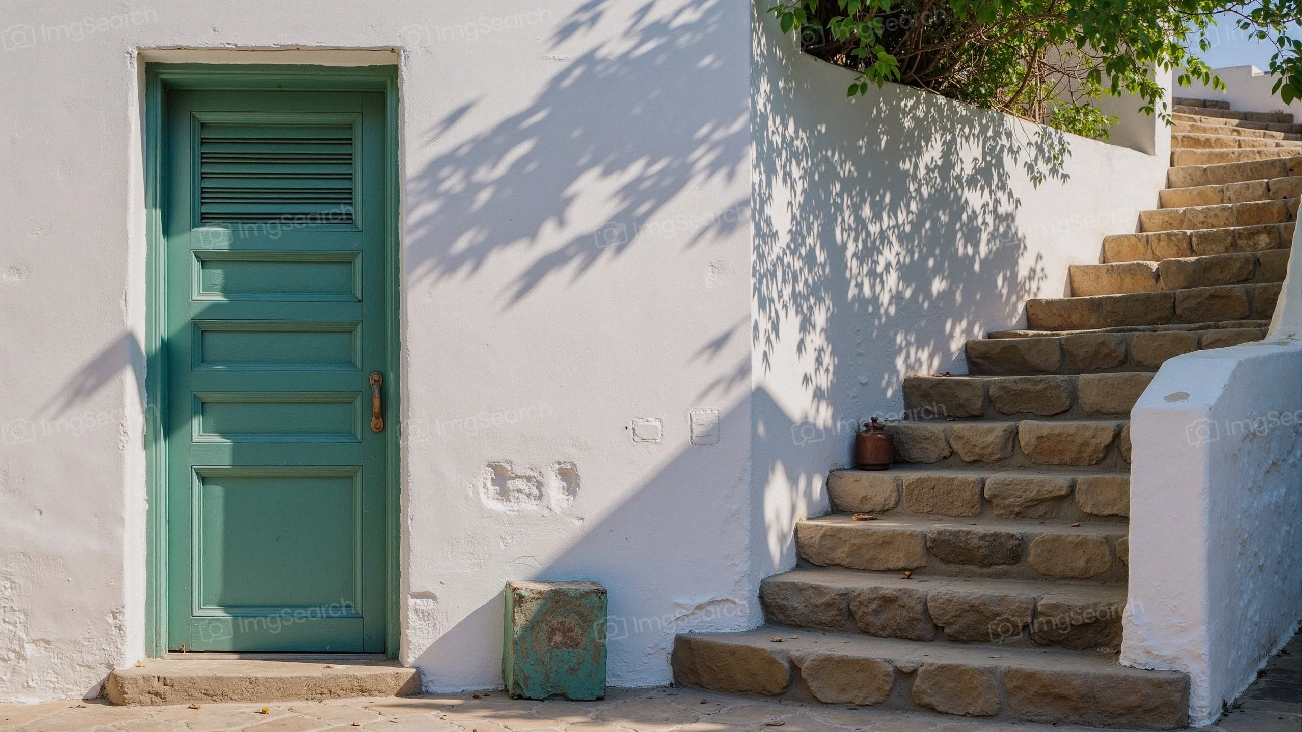 A charming green door rustic stone stairs against a white wall in a Mediterranean setting
