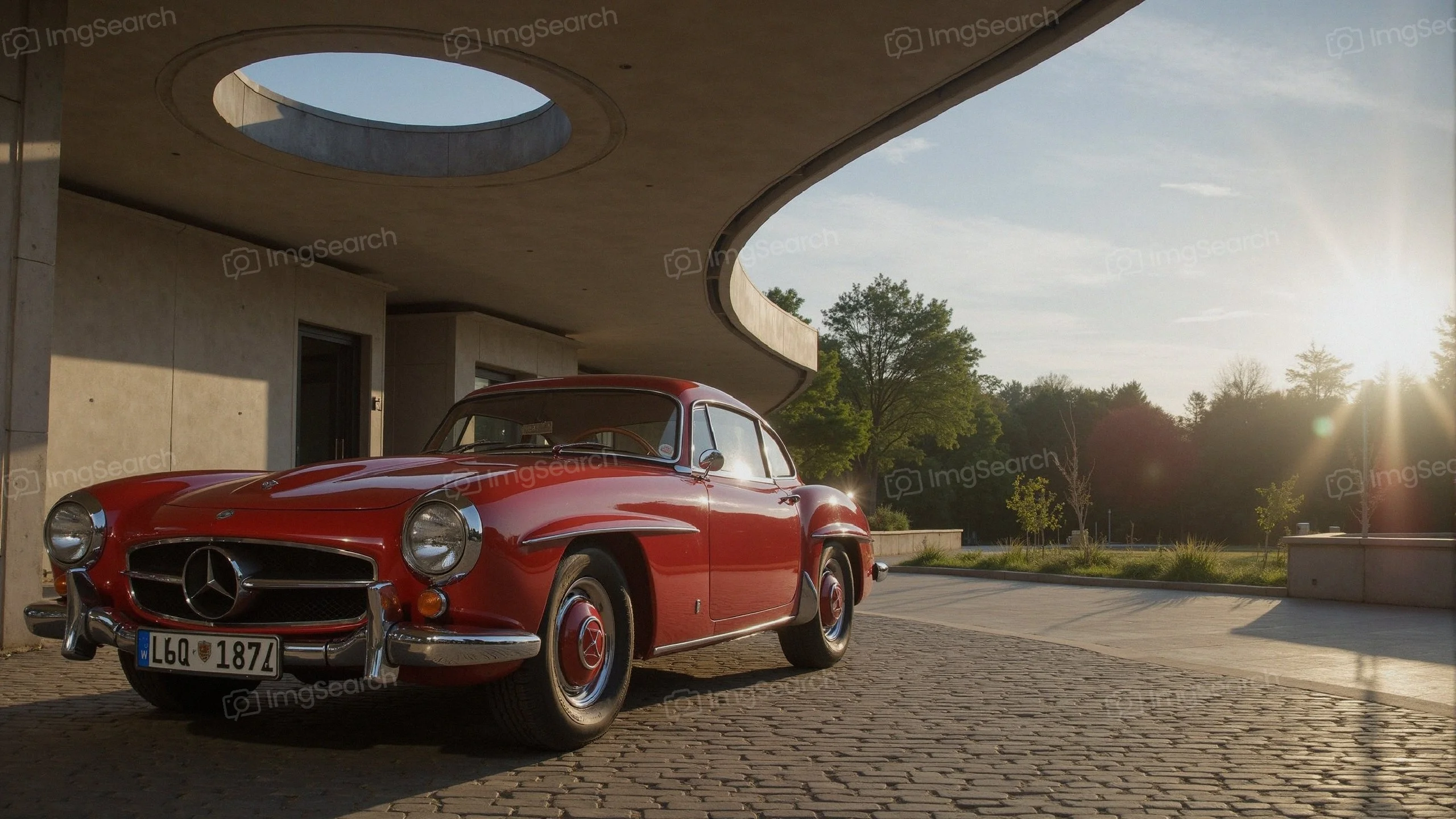A classic red Mercedes-Benz 300SL parked in front of a modern building basking in sunlight.