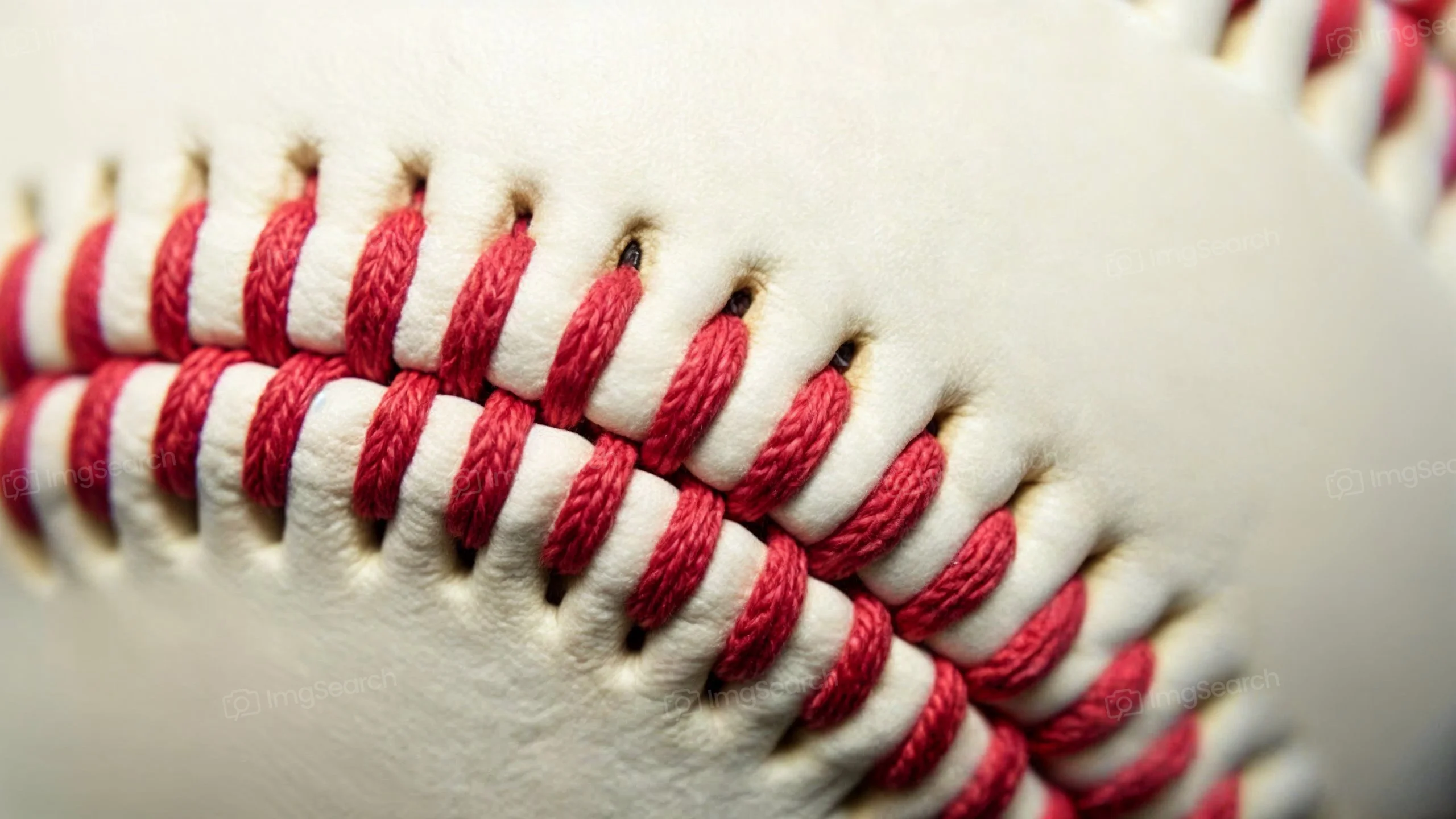 Close-up of a baseball showing red stitching on white leather