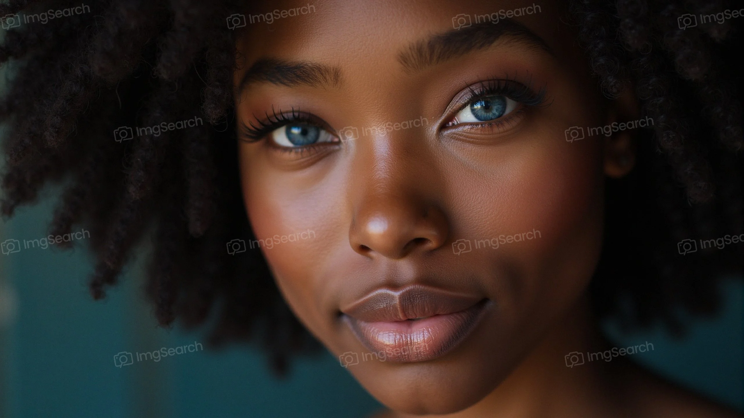 Close-up of a young woman with curly hair blue eyes