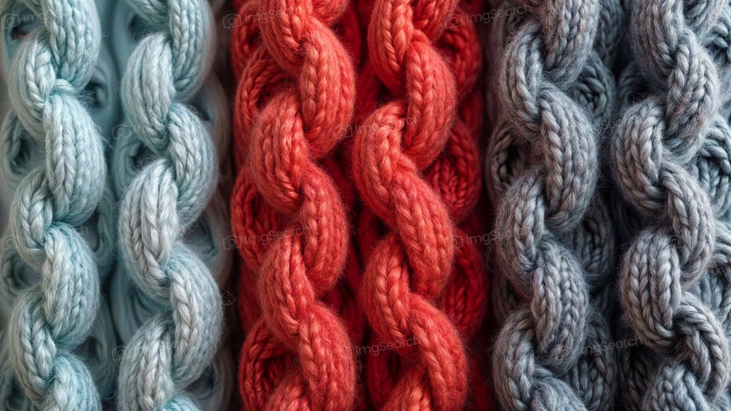 Close-up of braided yarn strands in blue, coral, and gray colors