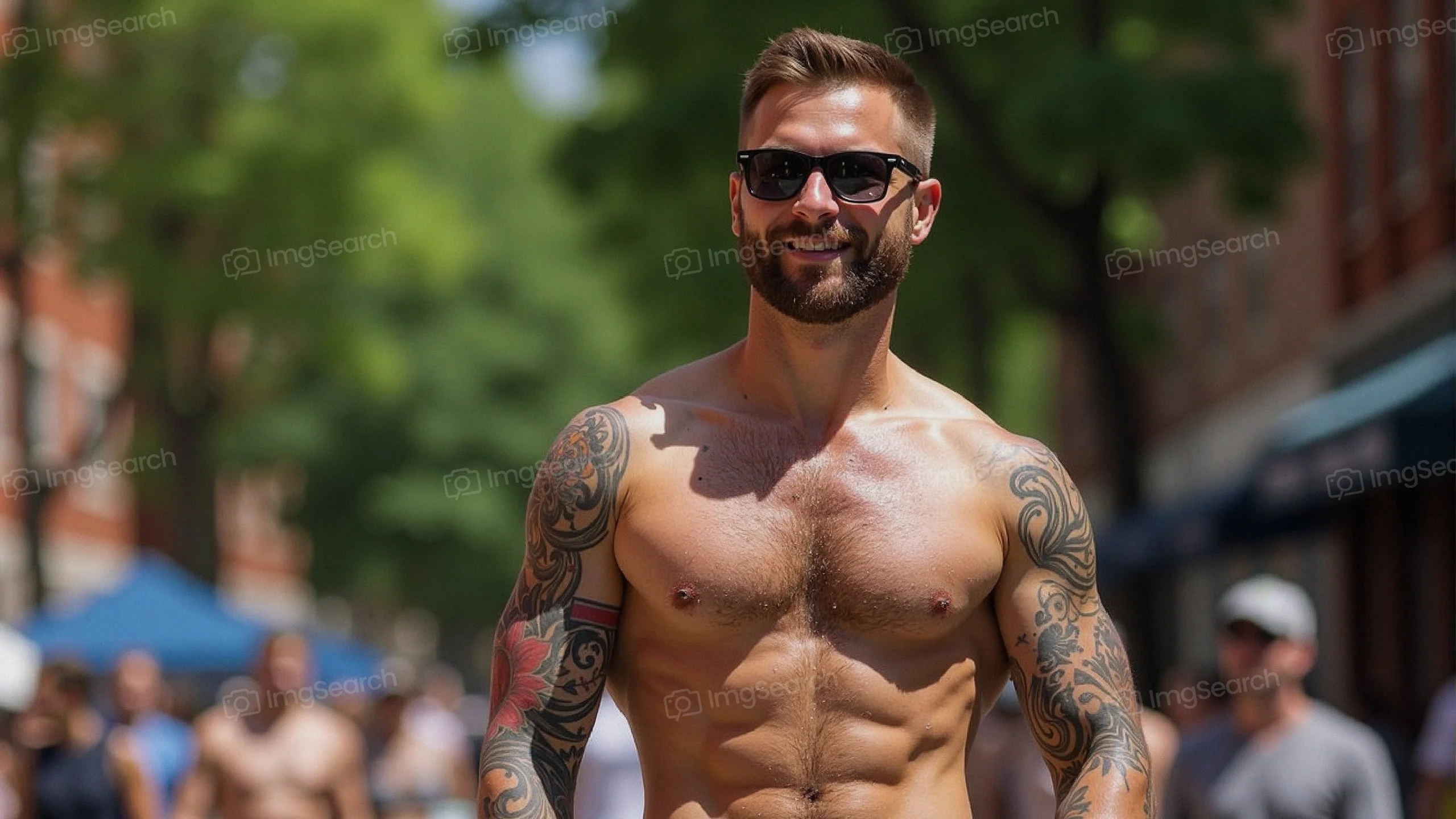 Muscular man with tattoos wearing sunglasses in a sunny urban setting