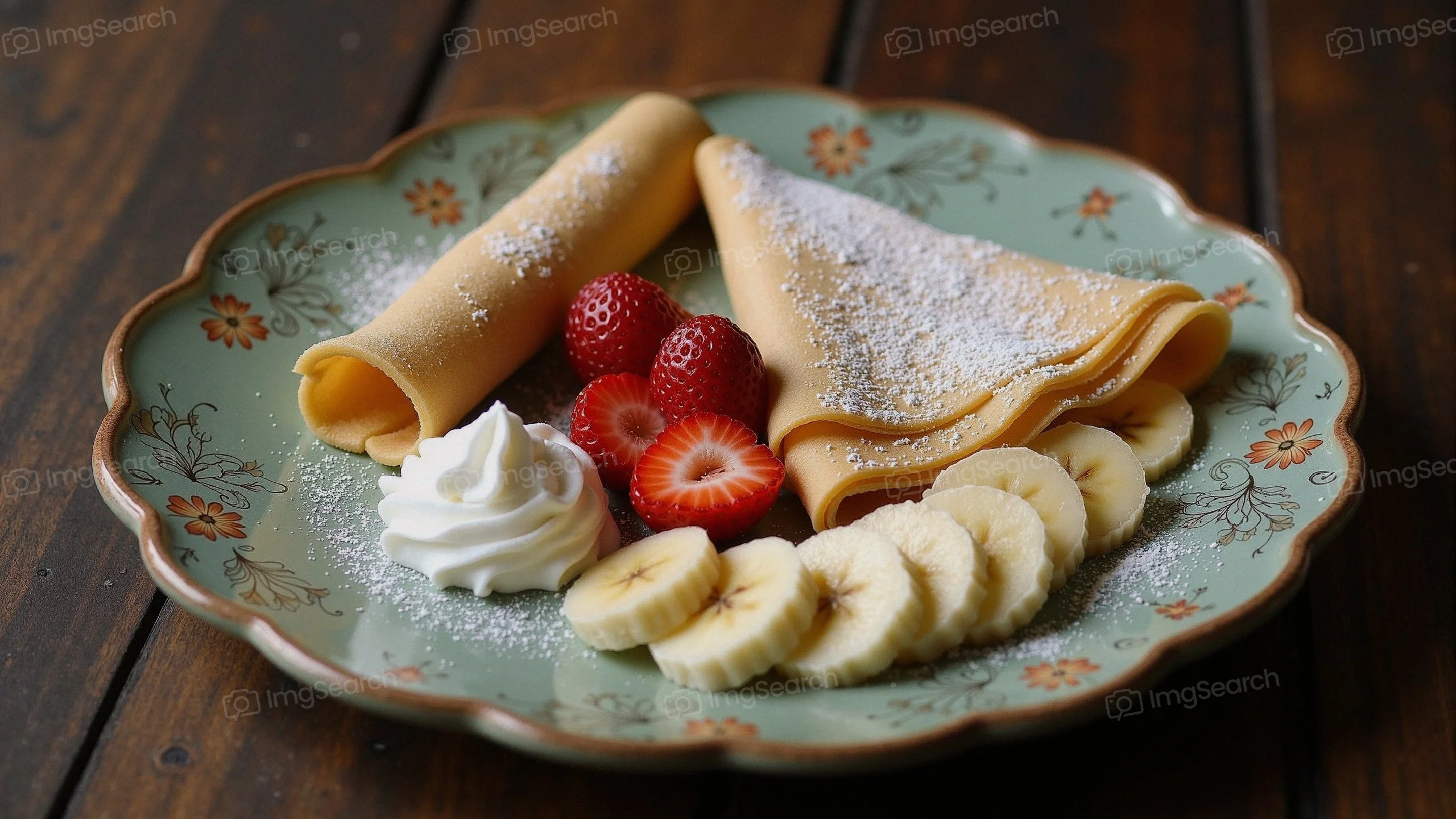 Plate of crepes with strawberries, bananas, whipped cream, powdered sugar