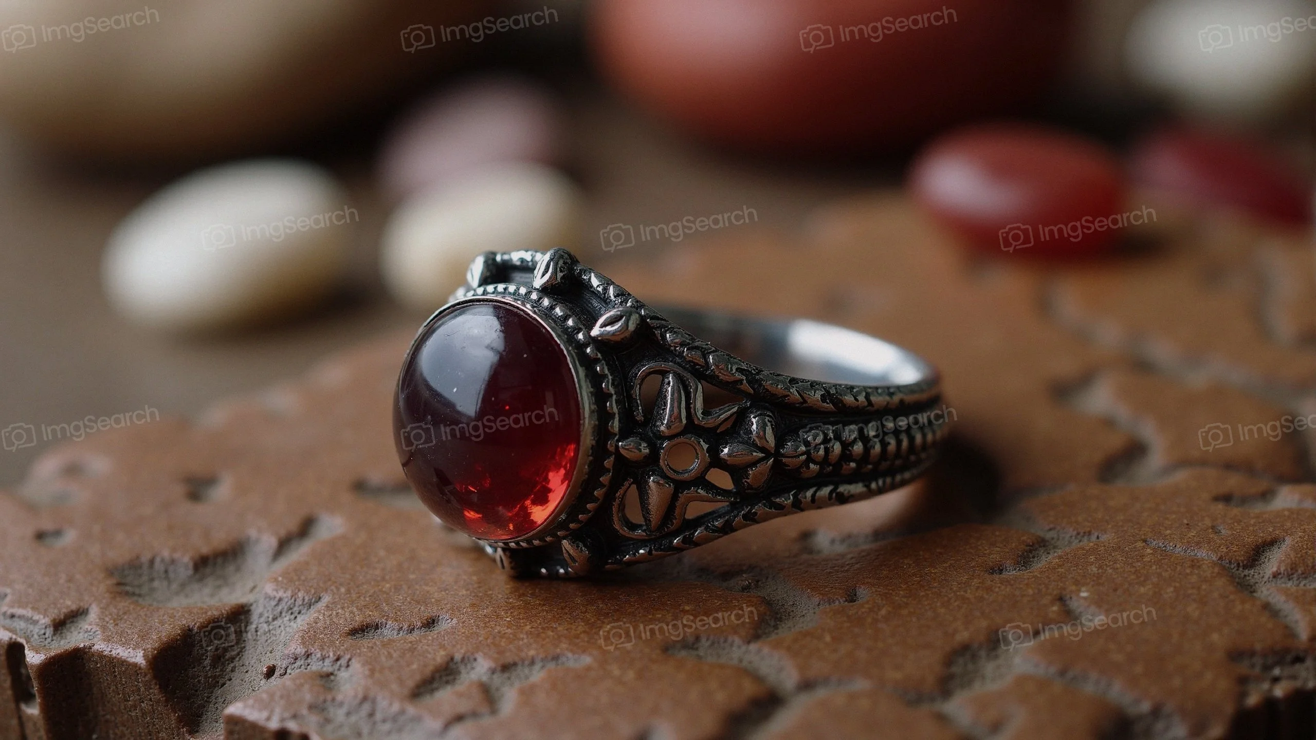 Vintage silver ring with red gemstone on textured background