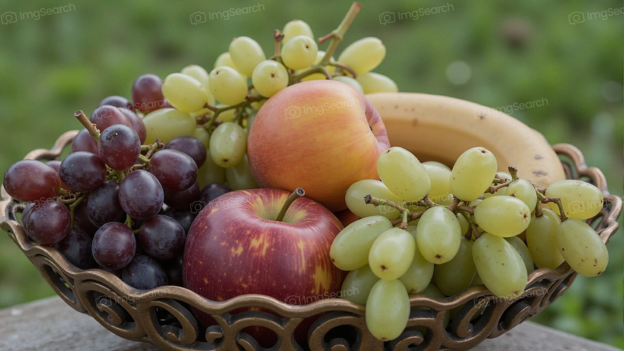 A bowl filled with an assortment of fresh fruits including grapes, apples, a peach, a banana.