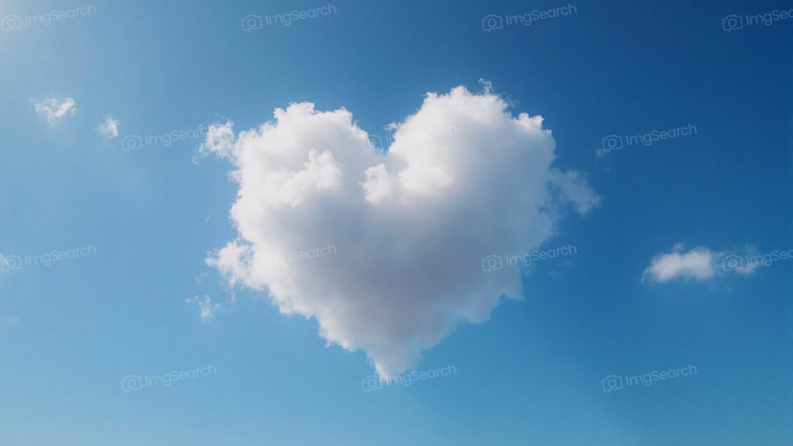 A heart-shaped cloud floating in a clear blue sky