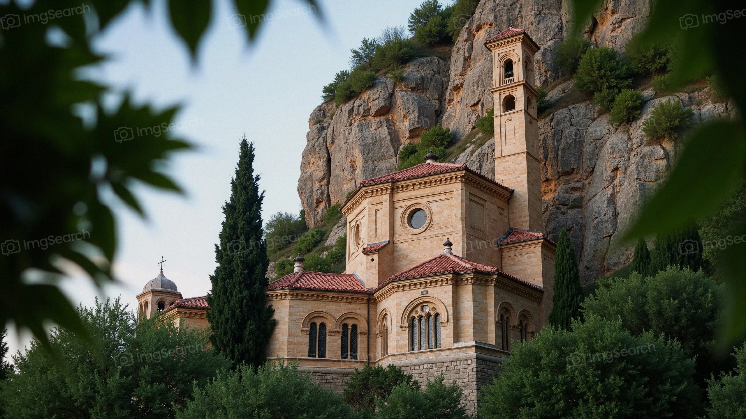 A beautiful monastery located on a cliff surrounded by trees rocky terrain.