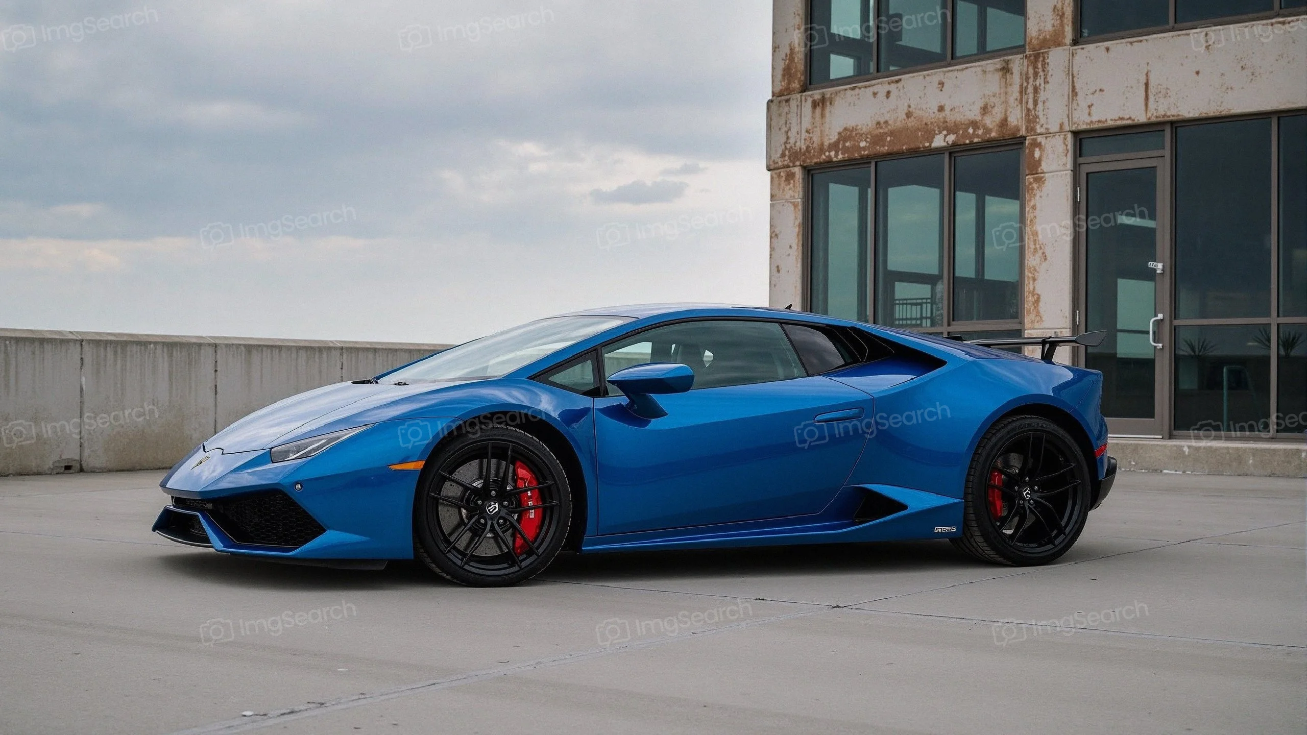 A blue Lamborghini Huracán parked in an urban setting.