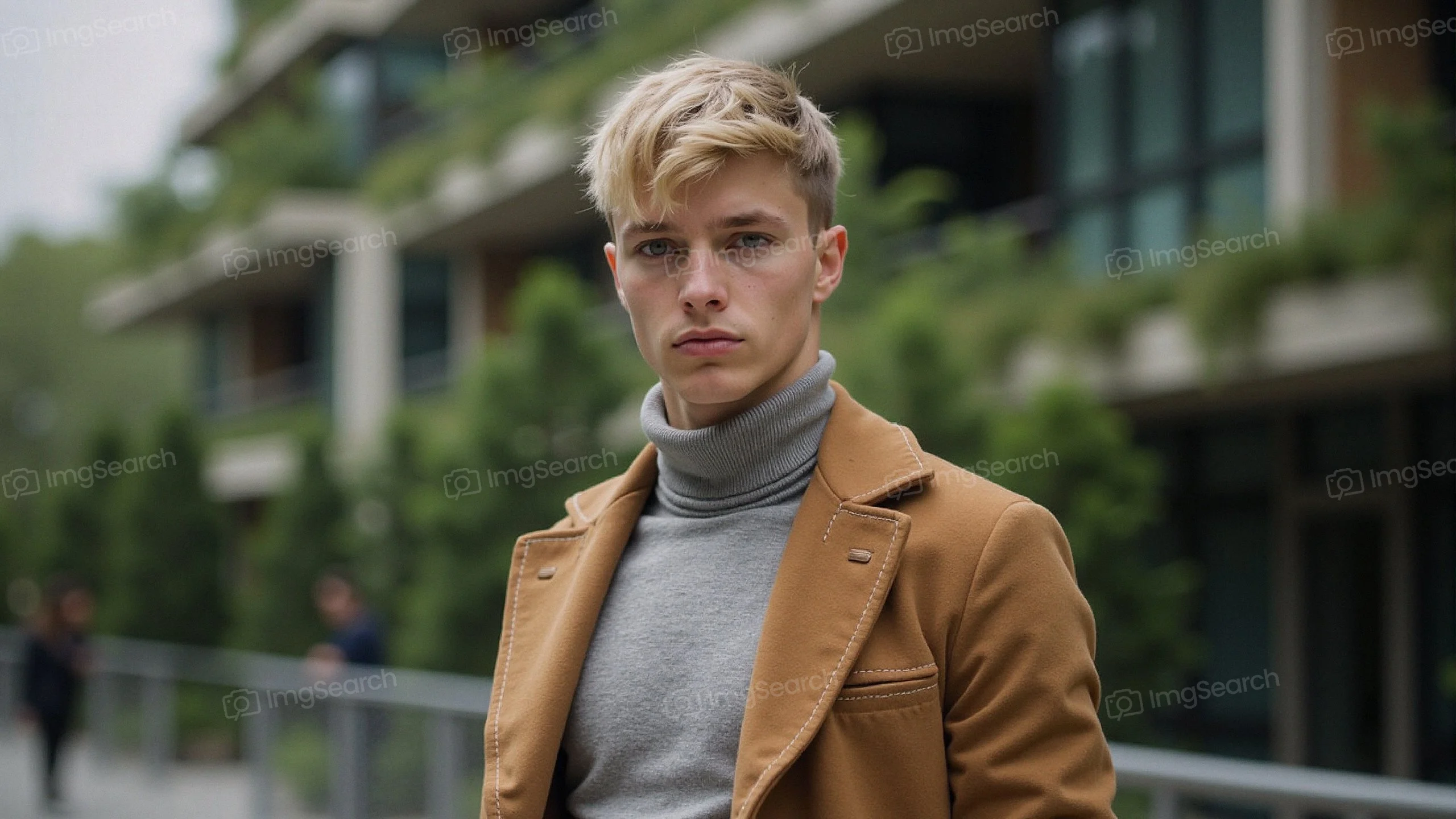 Stylish young man in tan coat gray turtleneck in city environment