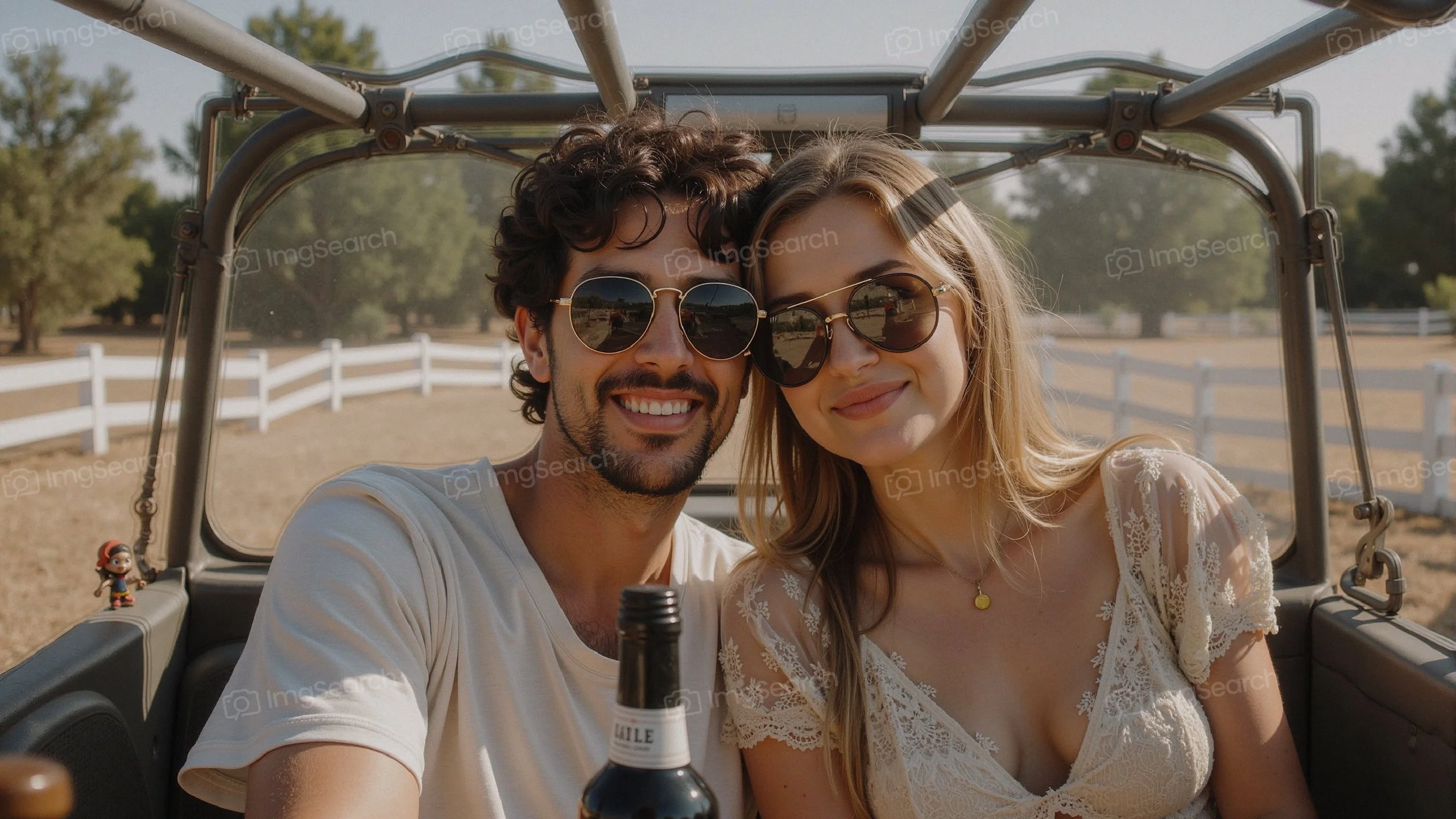 A young couple with sunglasses enjoying a sunny day in a vintage vehicle.