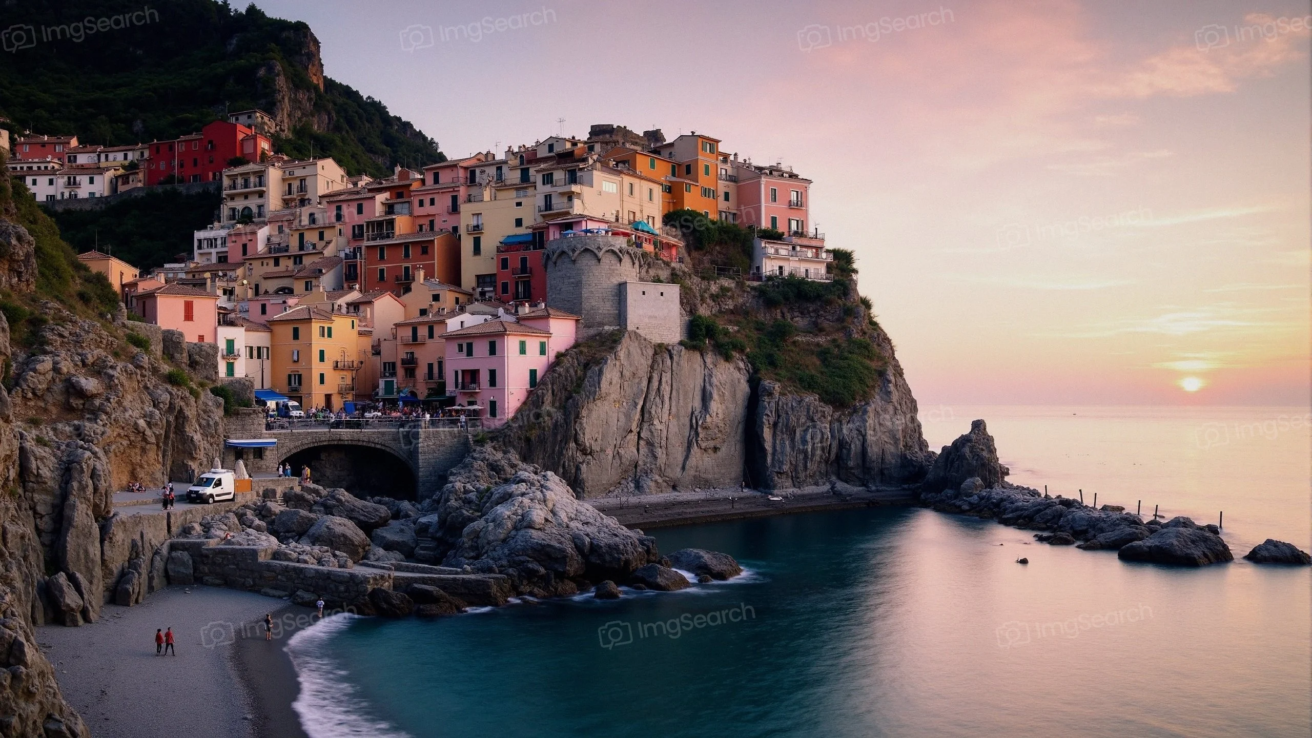 A picturesque coastal village with colorful houses atop a rocky cliff during sunset.