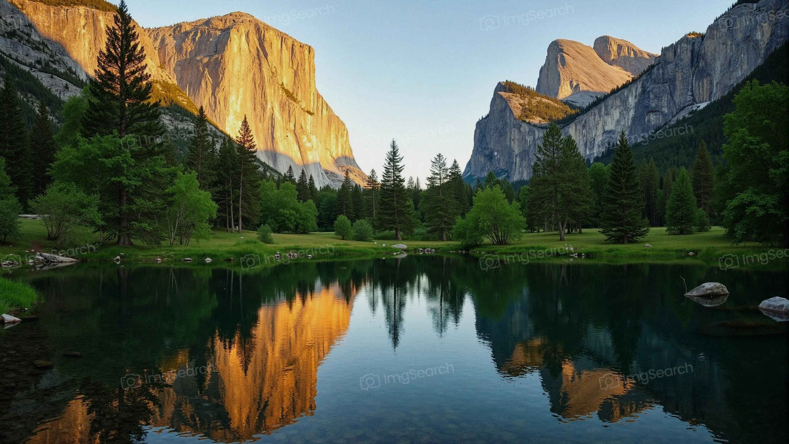 A view of Yosemite Valley with reflecting water towering granite cliffs at sunset