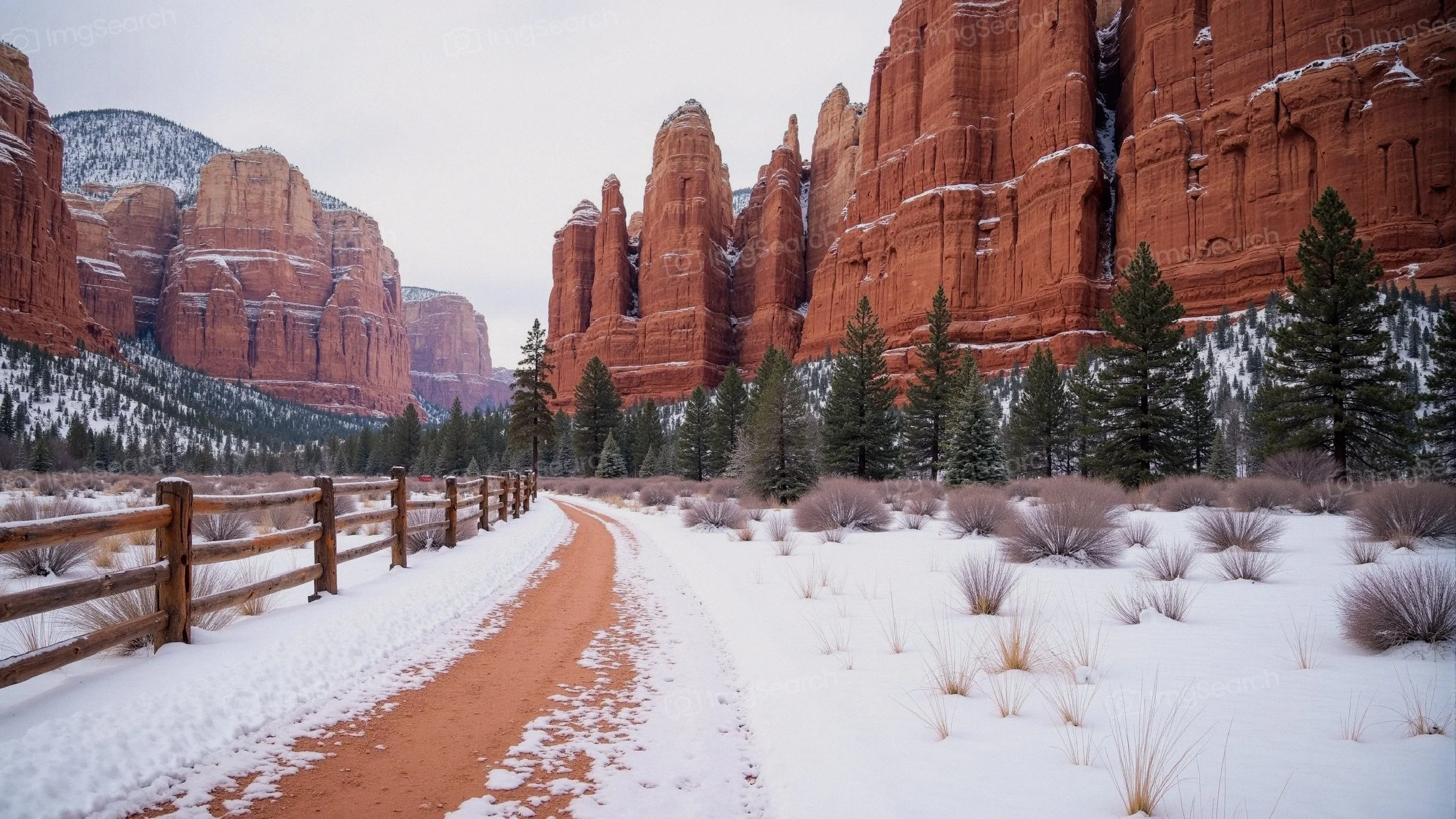 Winter landscape showing a winding path through red rock formations snow-covered ground